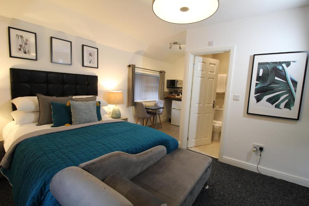伍尔弗汉普顿霍尔康柏公寓式酒店的一间卧室配有一张床和一张沙发