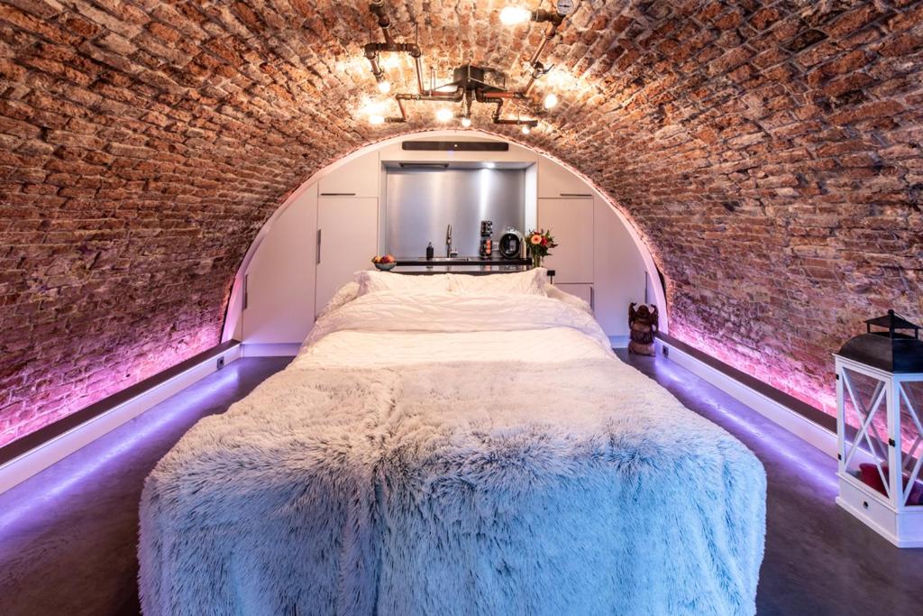 乌得勒支UKI-Hotel的卧室设有一张砖墙内的大床