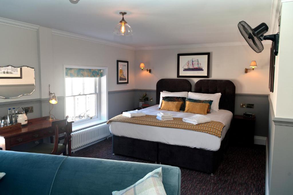 伦敦Admiral Hardy的一间卧室配有一张大床和一张蓝色的沙发