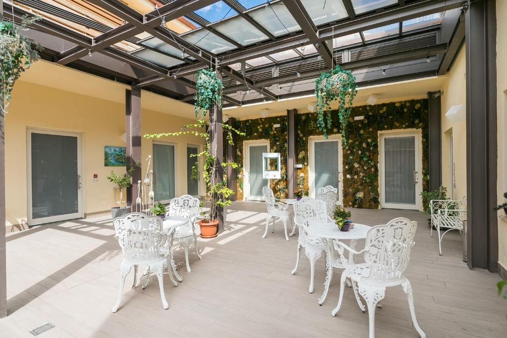 罗马Demetra Eco Guest House的庭院配有白色的桌椅和植物