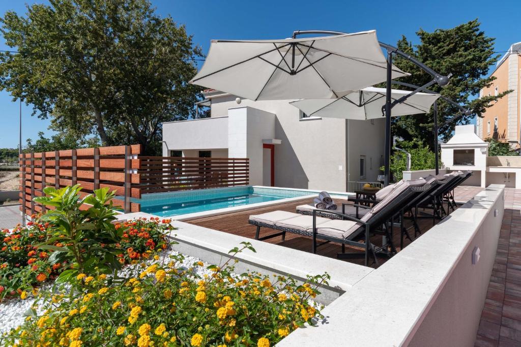 珀德垂那Apartment House Ivan John的后院设有游泳池和带遮阳伞的庭院。