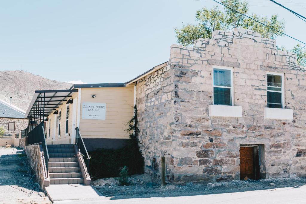 托诺帕Old Brewery Hostel的一座古老的石头建筑,设有楼梯和门