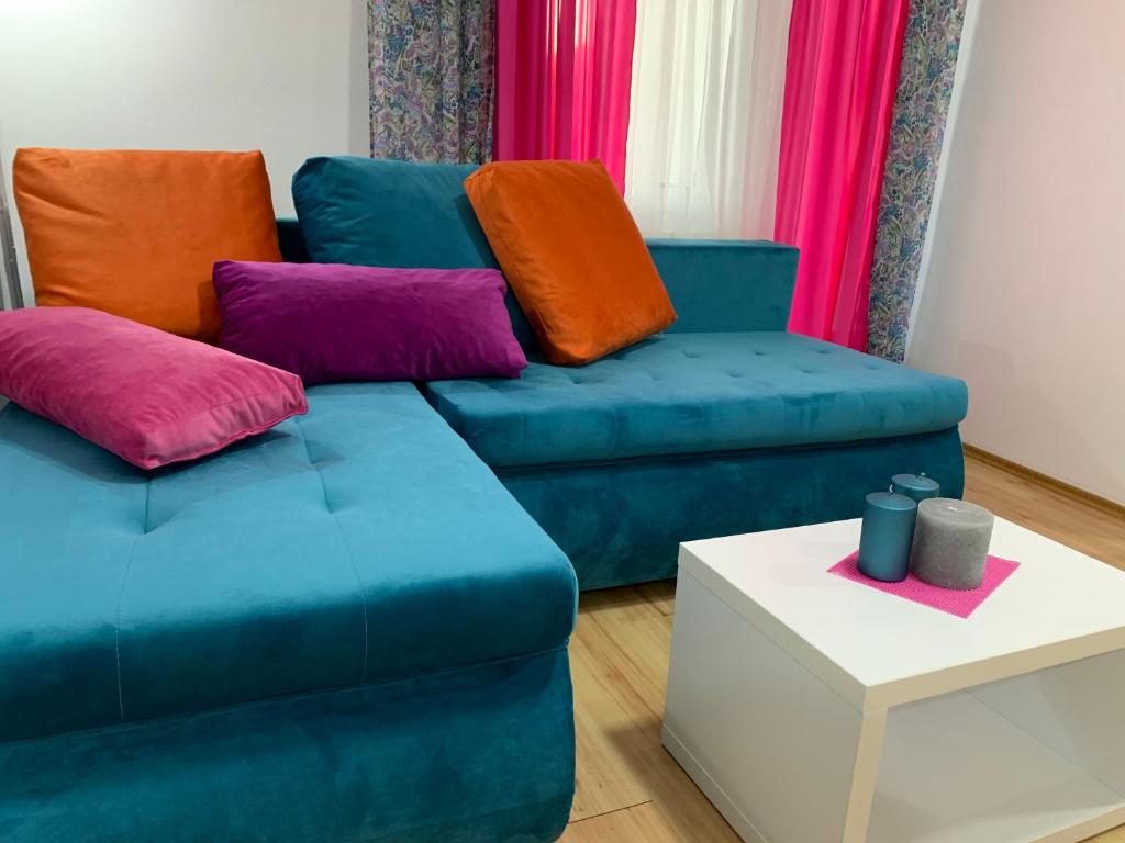 雅戈丁那La Apartamento Centroom的客厅配有蓝色的沙发和色彩缤纷的枕头。
