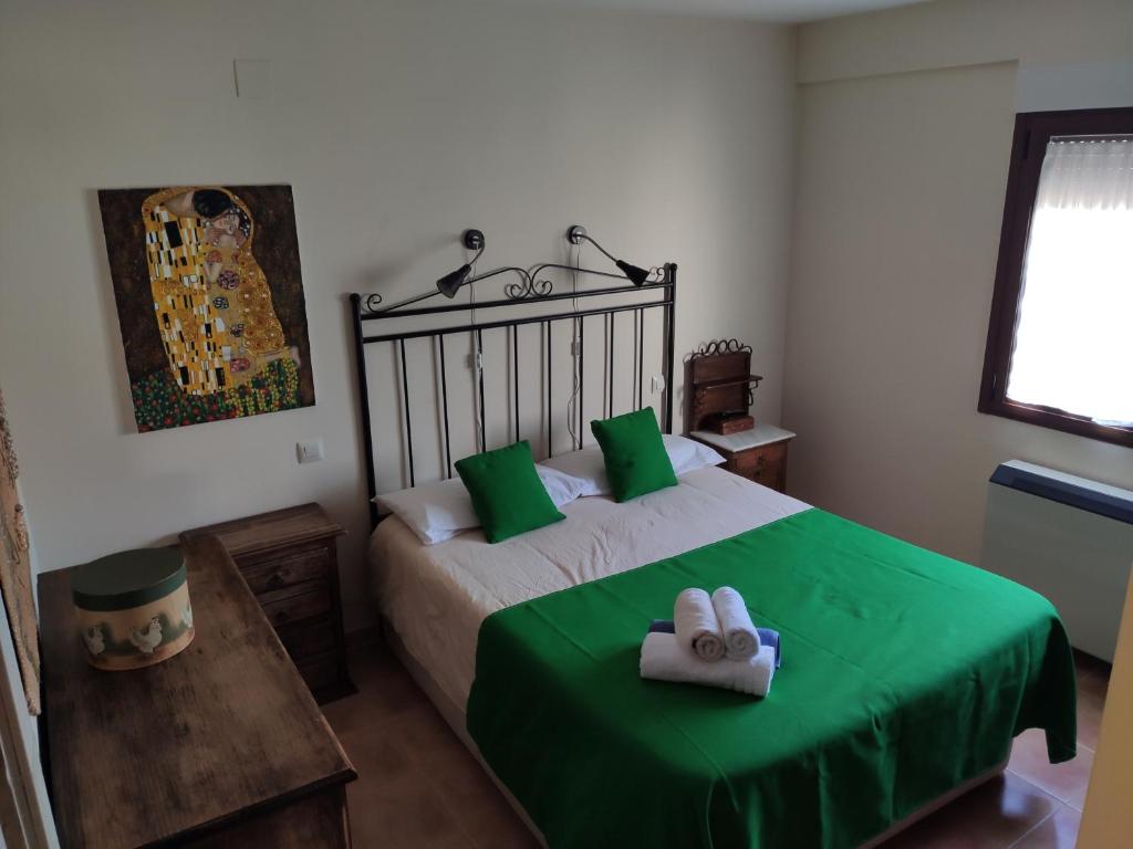 阿维拉VUT Casa Helen的一间卧室配有带绿色床单和毛巾的床。
