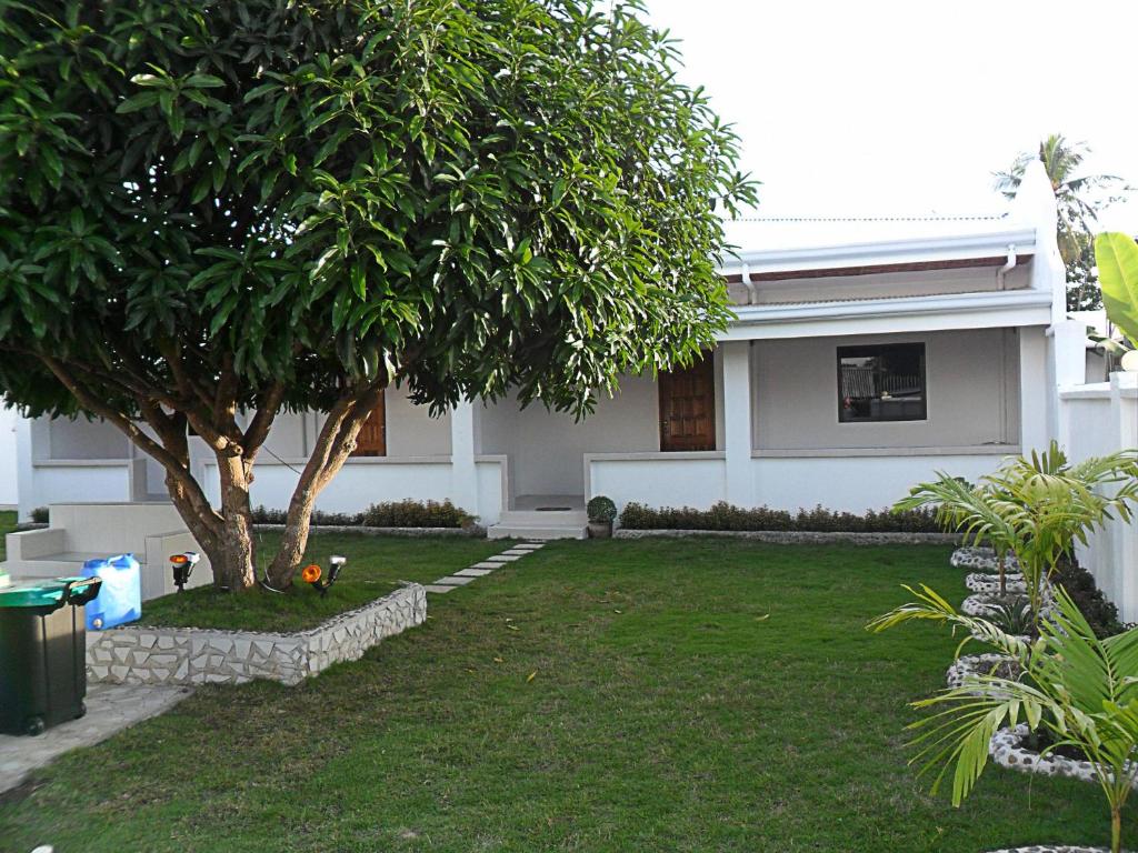 莫阿尔博阿Jasmin's Room Rental的院子里有树的白色房子