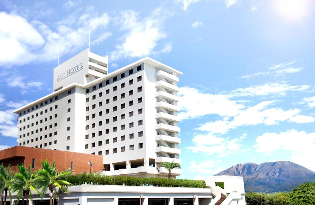 鹿儿岛Art Hotel Kagoshima的一座白色的大建筑,背景是一座山