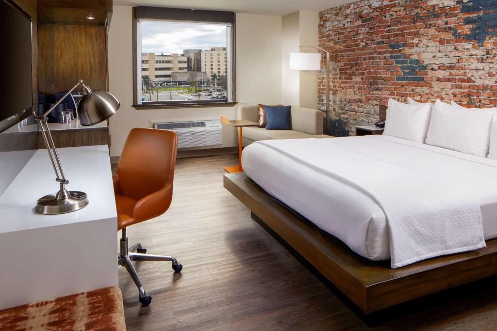 达拉姆The Lodge at Duke Medical Center的酒店客房,设有床铺和砖墙