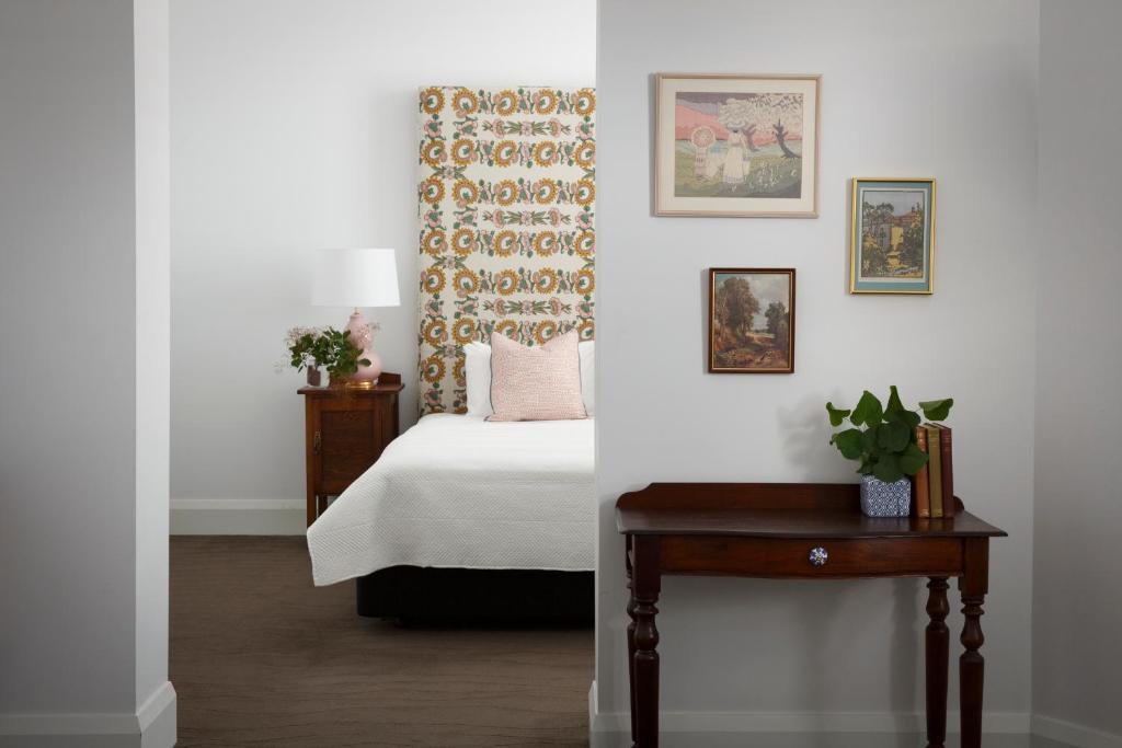 巴拉腊特The Provincial Boutique Hotel的一间卧室配有一张床和一张植物桌子
