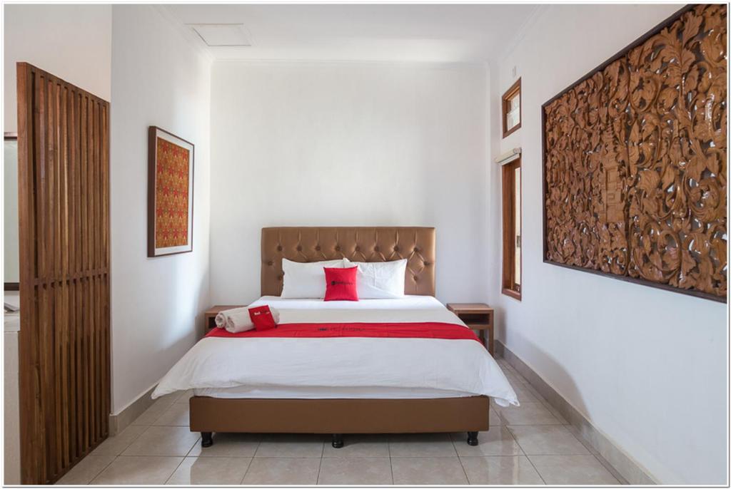 登巴萨Koolkost near Padang Galak Beach的一间卧室配有一张带红色枕头的大床