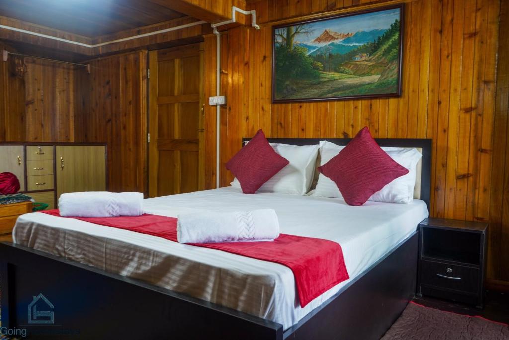 大吉岭Hidden Woods Homestay的一间卧室配有一张带红色枕头的大床