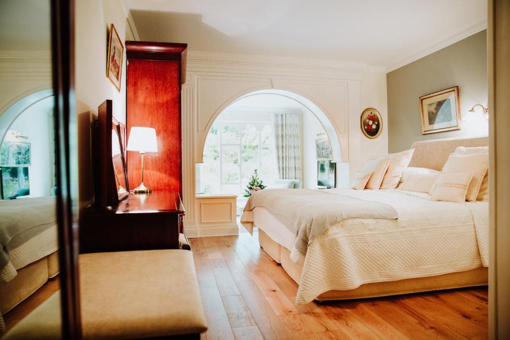 朗德斯通卡什尔小屋酒店的一间卧室设有一张大床和一个拱形窗户