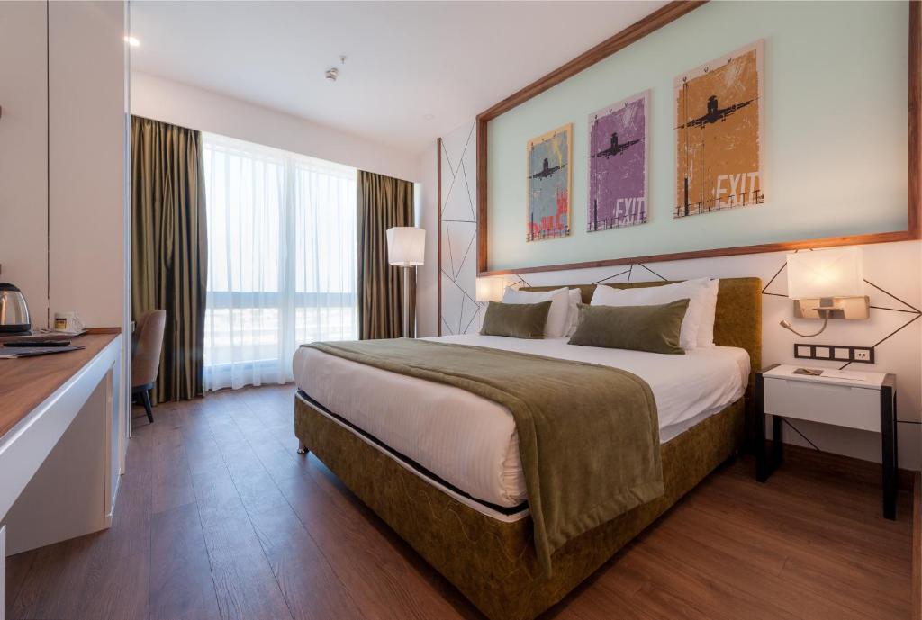 伊斯坦布尔萨宾纳戈琛ISG机场酒店的酒店客房设有一张大床和一张书桌。