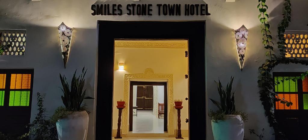 桑给巴尔Smiles Stone Town Hotel的走廊上设有门,还有书丝标志,一些联排别墅