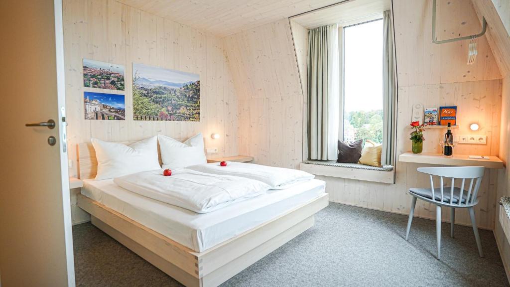 路德维希堡Hotel Bergamo的卧室设有一张白色大床和一扇窗户。