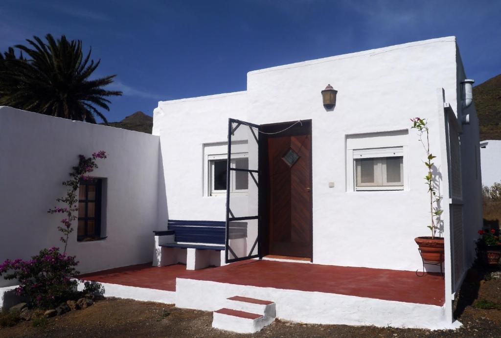 MáguezCASA DIANA的白色的房子,有门和长凳