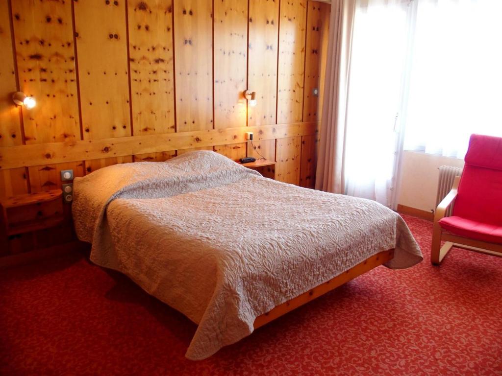 拉佩蒂特皮耶尔德沃思琪酒店的一间卧室配有一张床和一张红色椅子