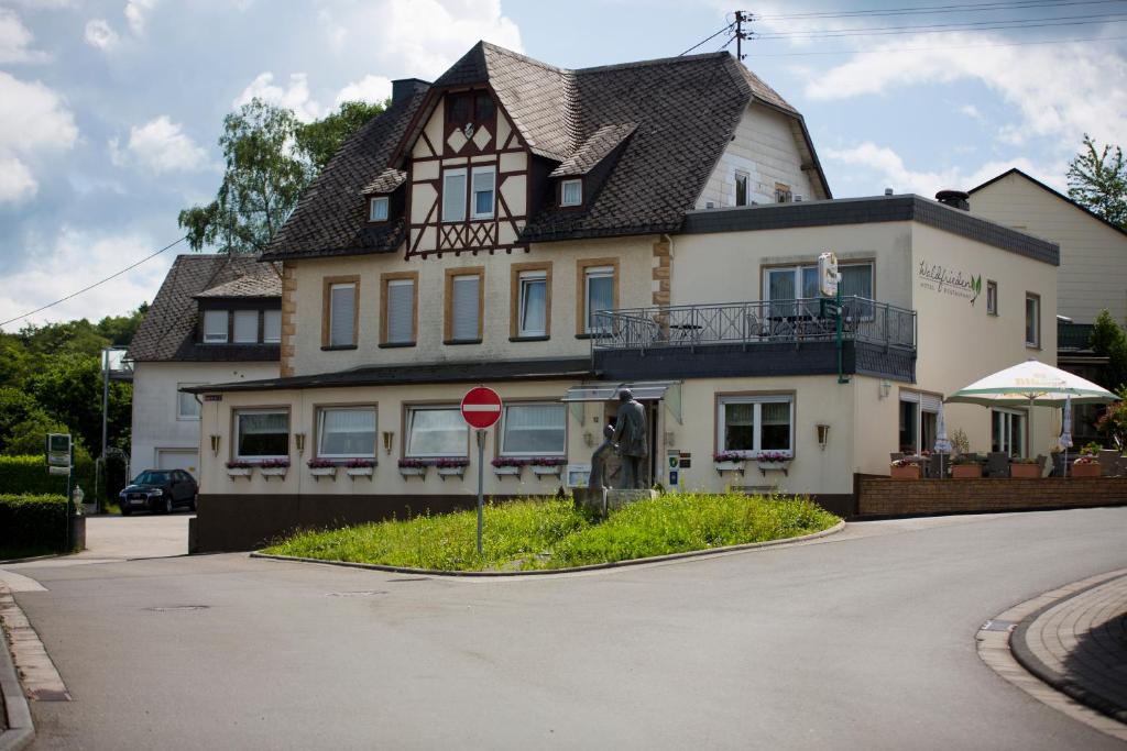 埃梅尔斯豪森Hotel Waldfrieden的前面有停车标志的大房子