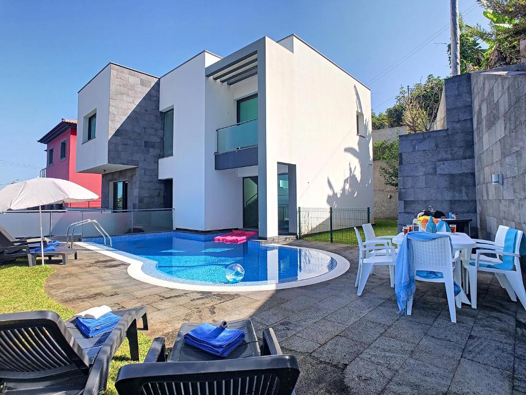蓬塔德尔加达Villa North Sea by LovelyStay的一个带桌椅的庭院和一个游泳池