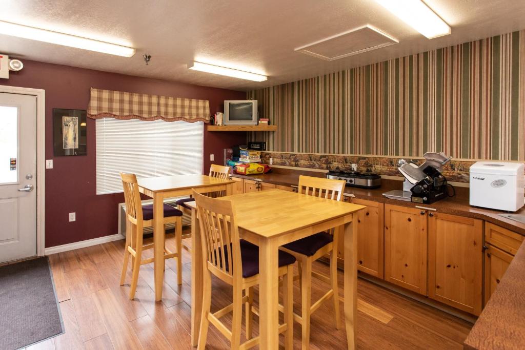 KingsleyThe Kingsley Suites的厨房配有木桌和椅子