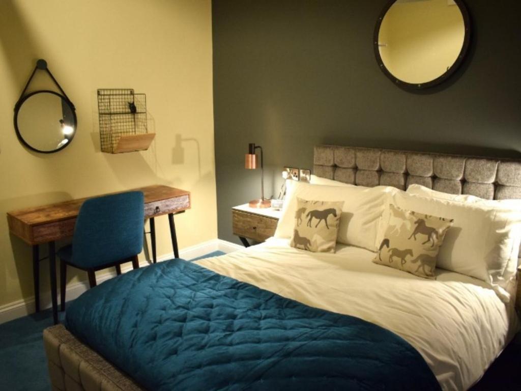 BinegarThe Mendip Inn的一间卧室配有一张床、一张书桌和一面镜子