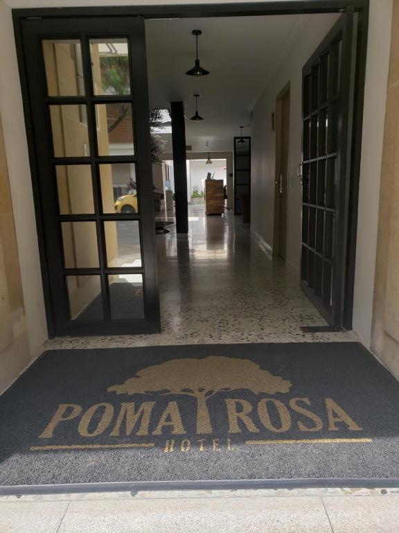 麦德林Hotel Poma Rosa的大堂设有一张地毯上的扑曼尼奥萨酒店标志