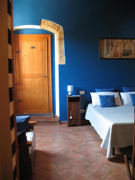圣吉米纳诺Locazione Turistica Totti的一间蓝色的卧室,配有一张床和一个木门