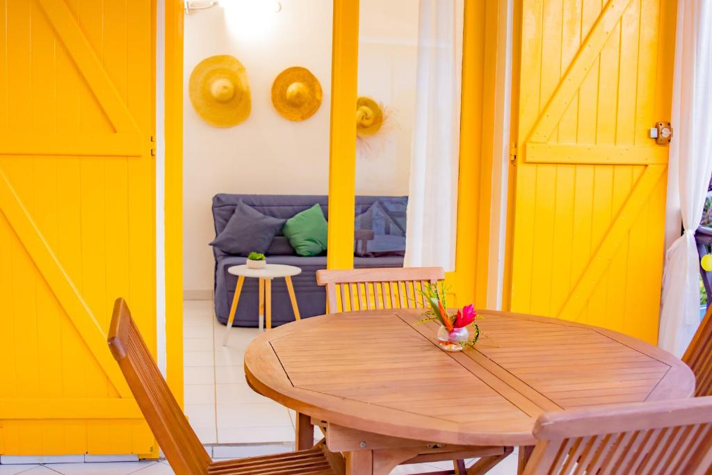 三河市Gîtes de Checheti的一间带木桌和沙发的用餐室