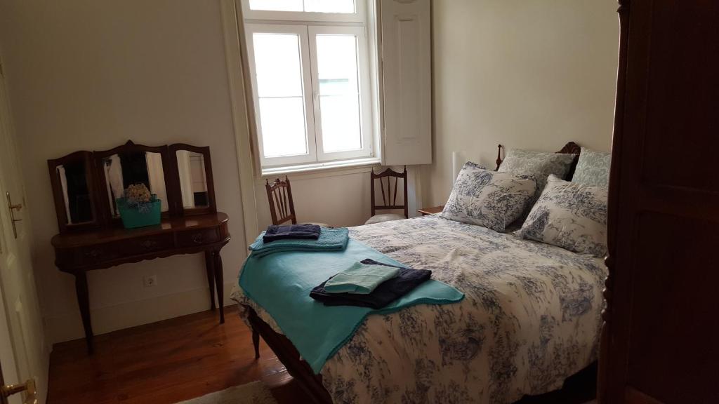里斯本Grandmommy's House - Traditional and comfy Lisboan apartment的一间卧室配有一张带镜子的床和窗户