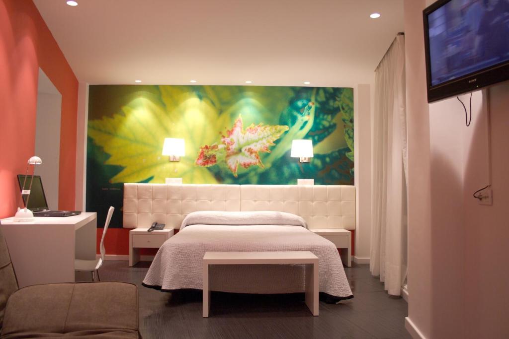 圣比森特德拉松谢拉松斯厄拉别墅酒店的卧室配有一张床,墙上挂有绘画作品