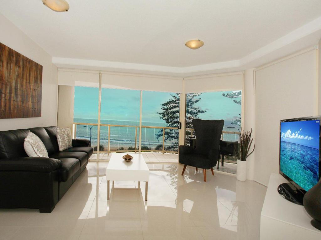 穆卢拉巴Zanzibar 404, Sensational 2 Bedroom Oceanview Apartment的客厅配有黑色沙发和钢琴