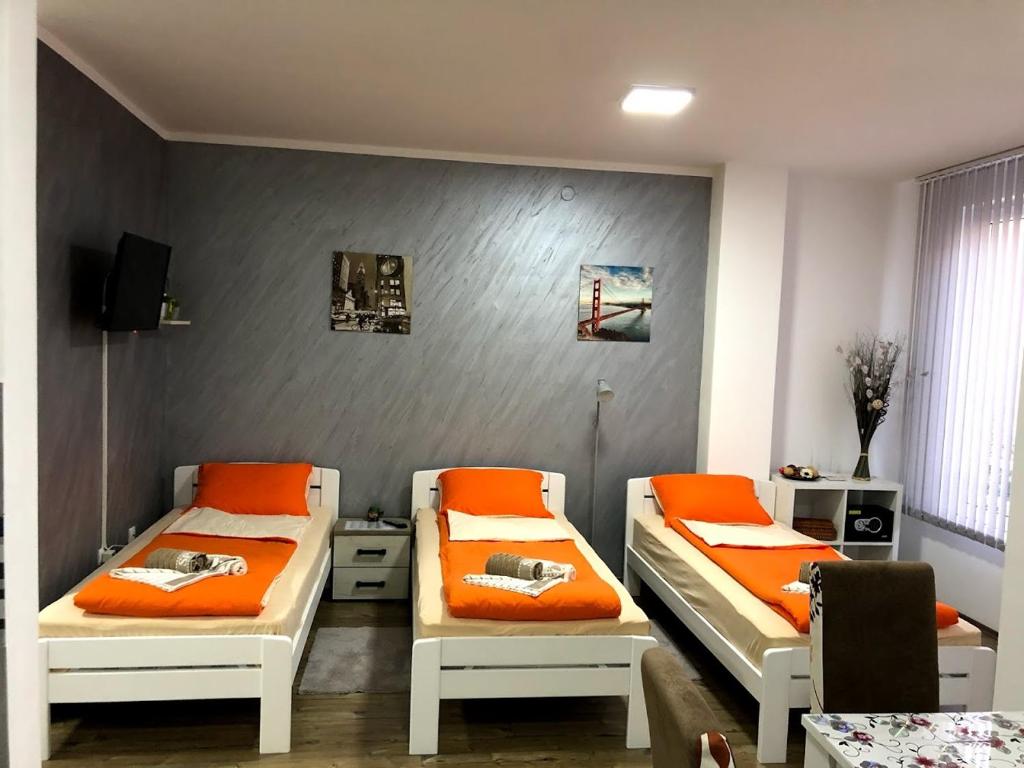 克拉多沃Apartman Bondi的配有橙色枕头的客房内的两张床