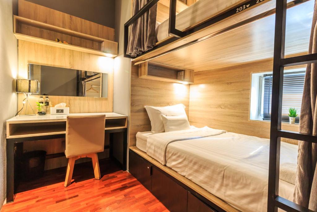 清迈泊斯特尔床铺旅馆的一间卧室配有一张床、一张书桌和一面镜子