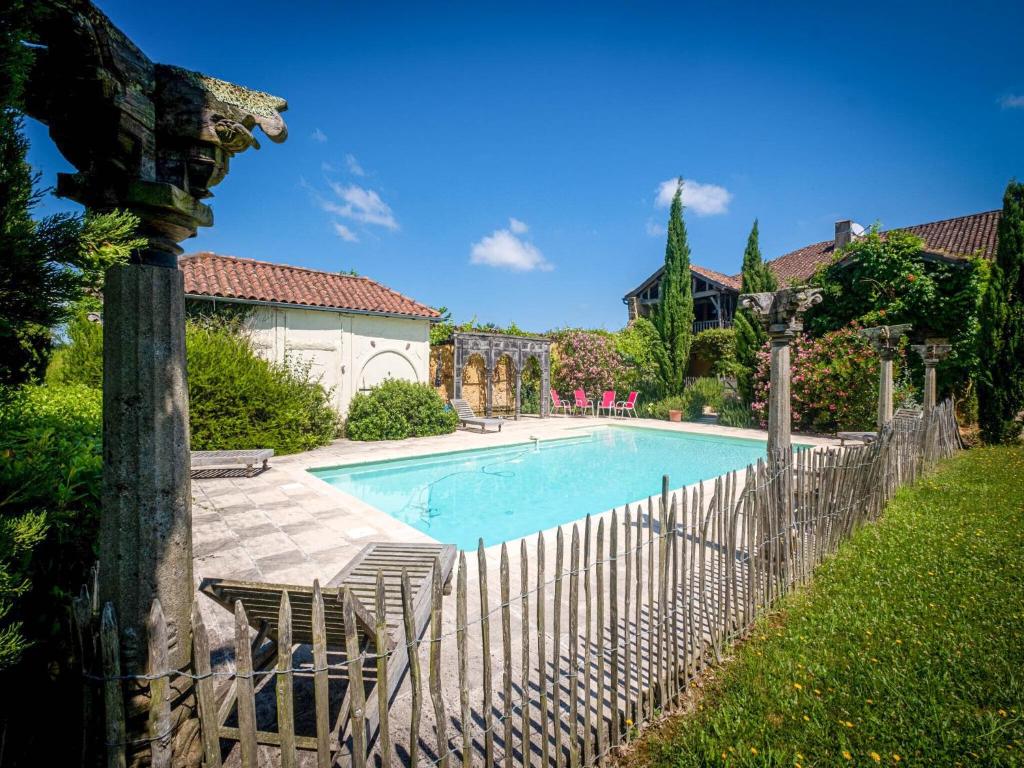Le HougaBeautiful farmhouse with private pool的一座房子旁带围栏的游泳池