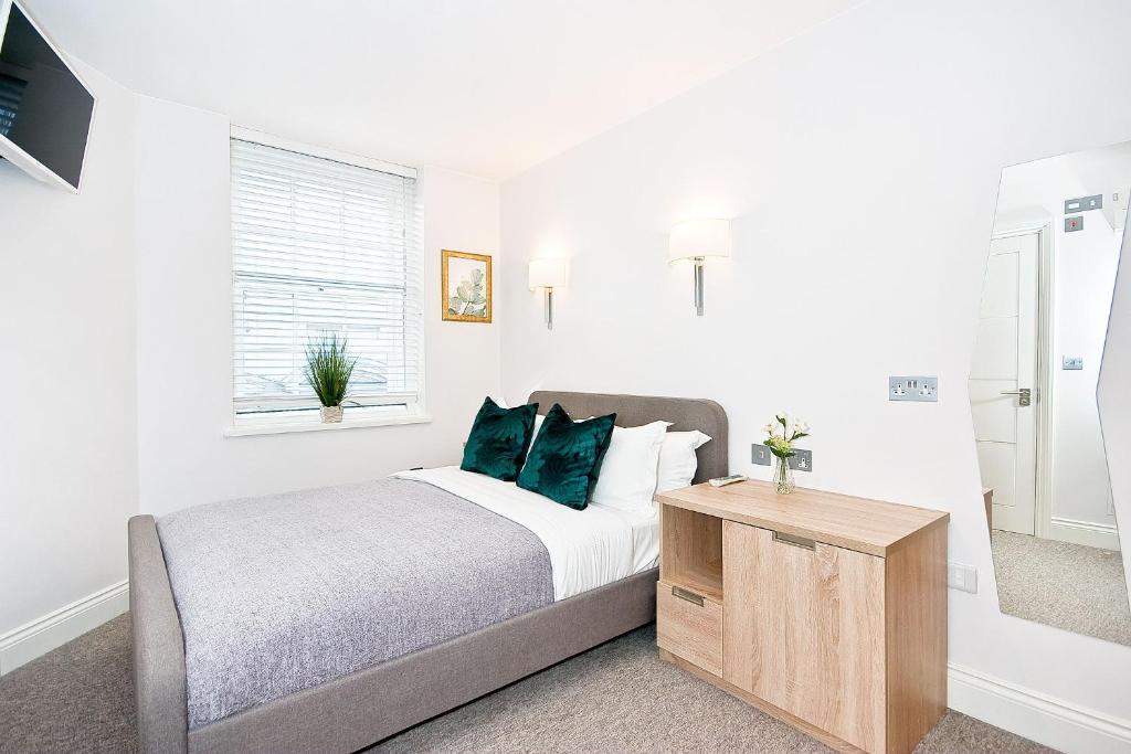 伦敦Eldon Chambers Pod 4 by City Living London的白色卧室配有带绿色枕头的床