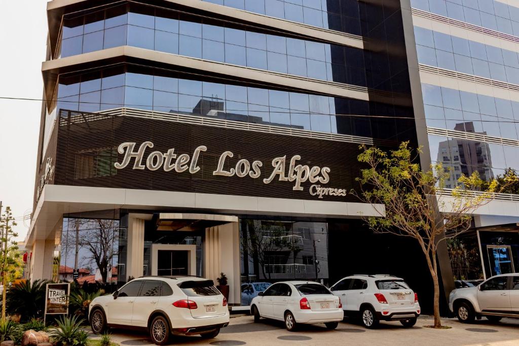 亚松森Hotel Los Alpes Cipreses的前面有汽车停放的建筑