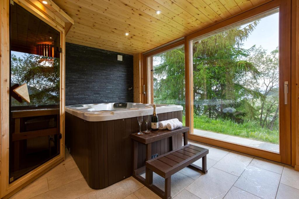 拉茨欧马兹Jacuzzi & Sauna | Chalet Teremok的一间带大浴缸和窗户的浴室