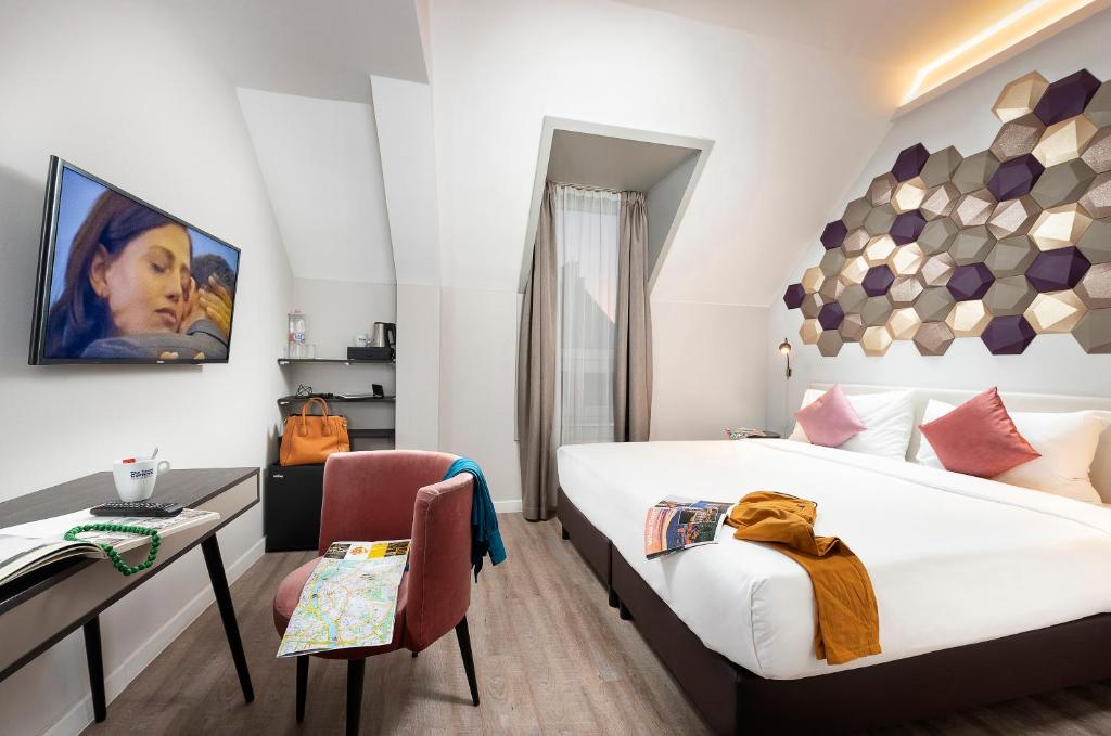 布达佩斯Three Corners Hotel Art的酒店客房配有一张床、一张桌子和一把椅子。