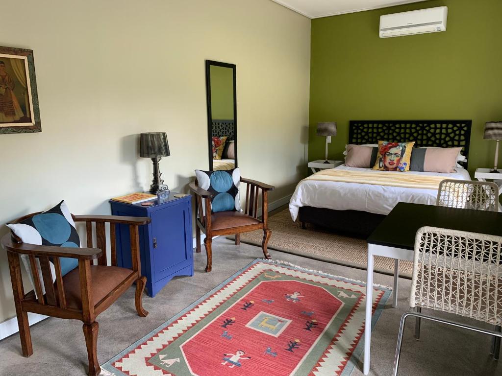 斯泰伦博斯Frida’s Place - Quiet in Stellenbosch Central的卧室配有一张床和一张桌子及椅子