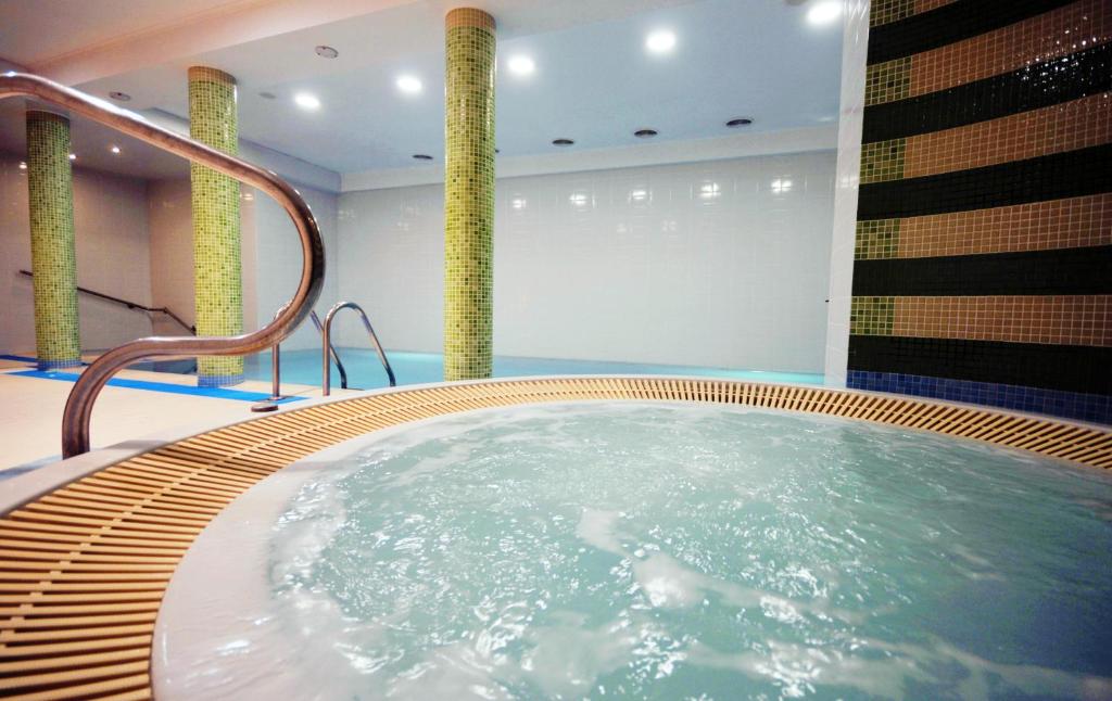 科沃布热格Bursztyn Spa的一个带柱子的房间的按摩浴缸