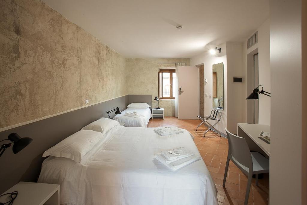 桑塔斯维尔Ostello del Castello di Santa Severa的一间卧室配有两张床和一张书桌