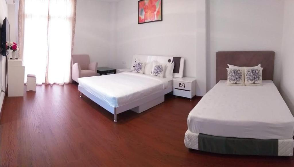 斯里巴加湾市Coconut Bay Lodge的一间卧室设有两张床,铺有木地板