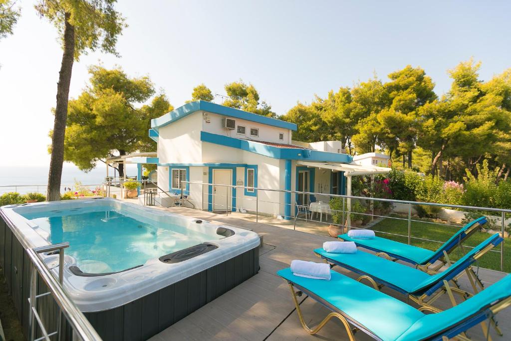 撒尼海滩Sani Beach Gallery Villa, your next family vacation!的一座带游泳池和两把椅子的房子