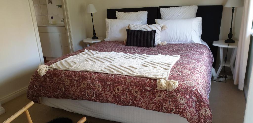 戴尔斯福特Astley Cottage的一张带红白毯子和枕头的床