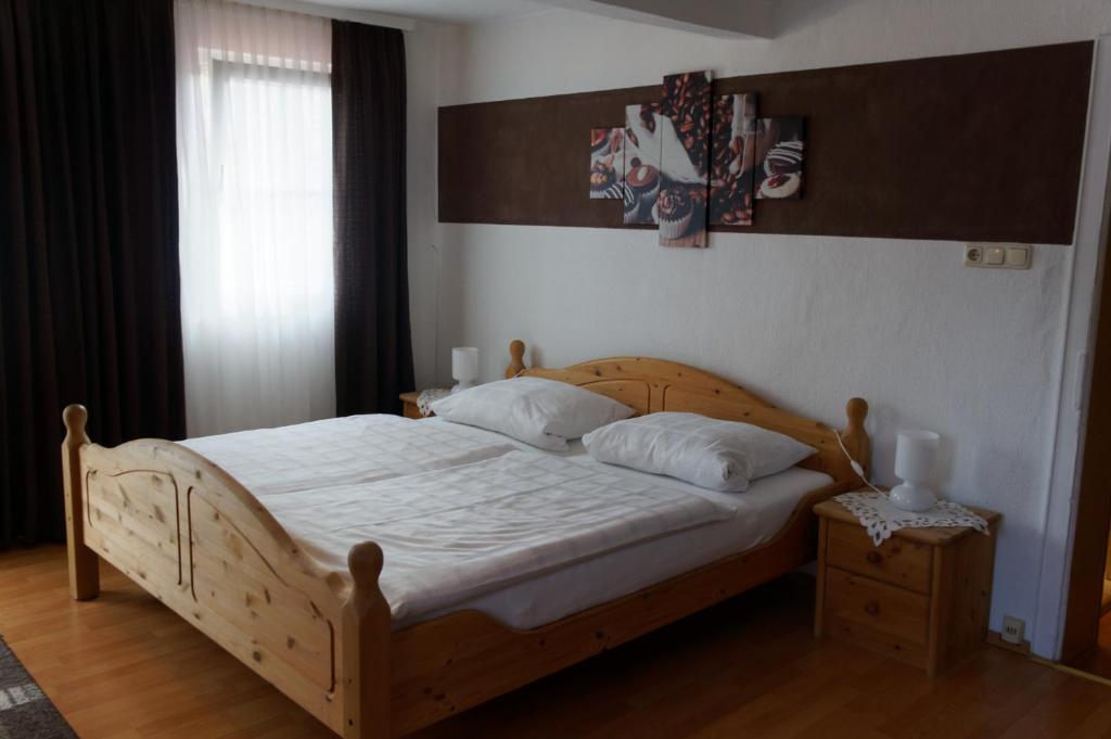 魏贝尔斯布伦Pension Burger B&B的一间卧室配有一张带白色床单和枕头的木制床。