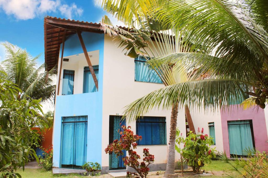 桑塔克鲁茨卡巴利亚Condominio Sao Cristovao的蓝色窗户和棕榈树的房子