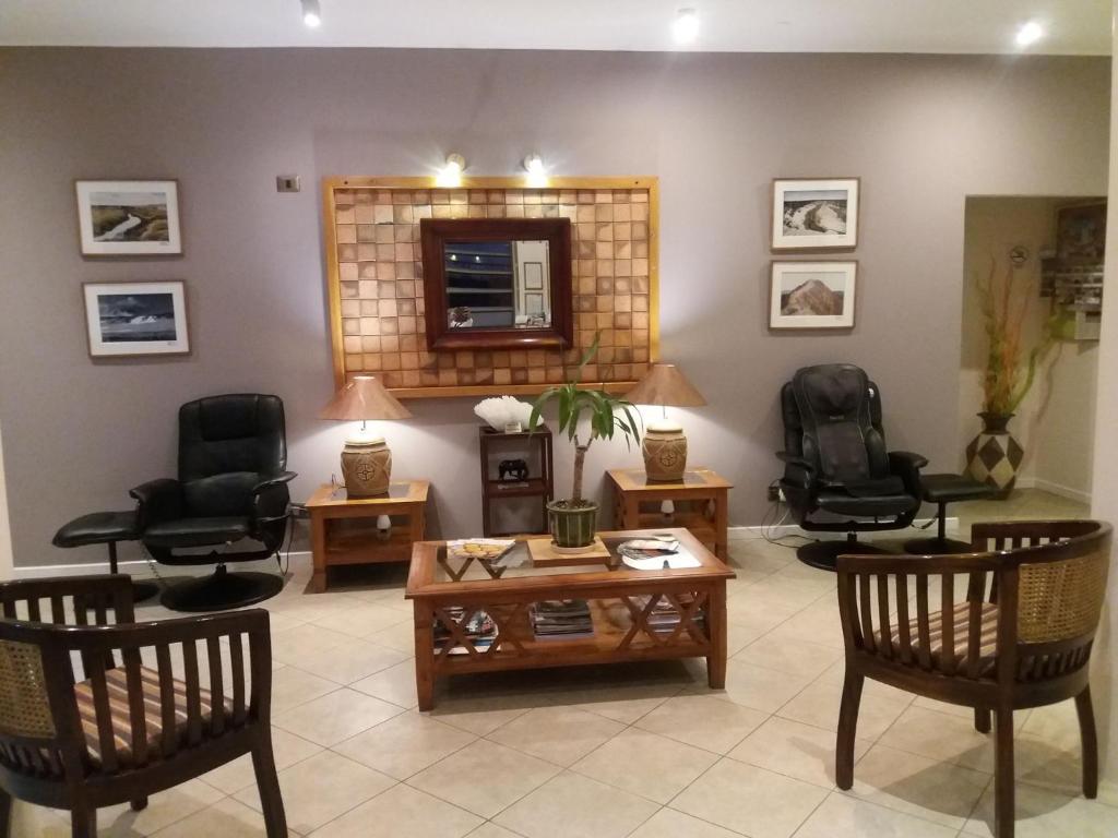 卡拉马阿叶林公寓酒店的客厅配有椅子、桌子和镜子