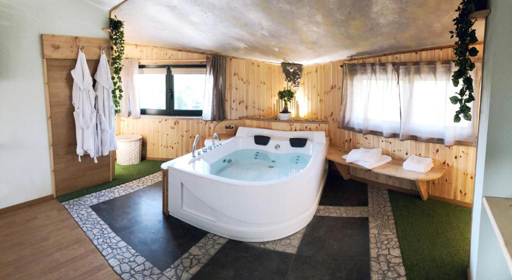 安圭拉萨巴齐亚REnt Room Wood的木墙客房内的大浴缸