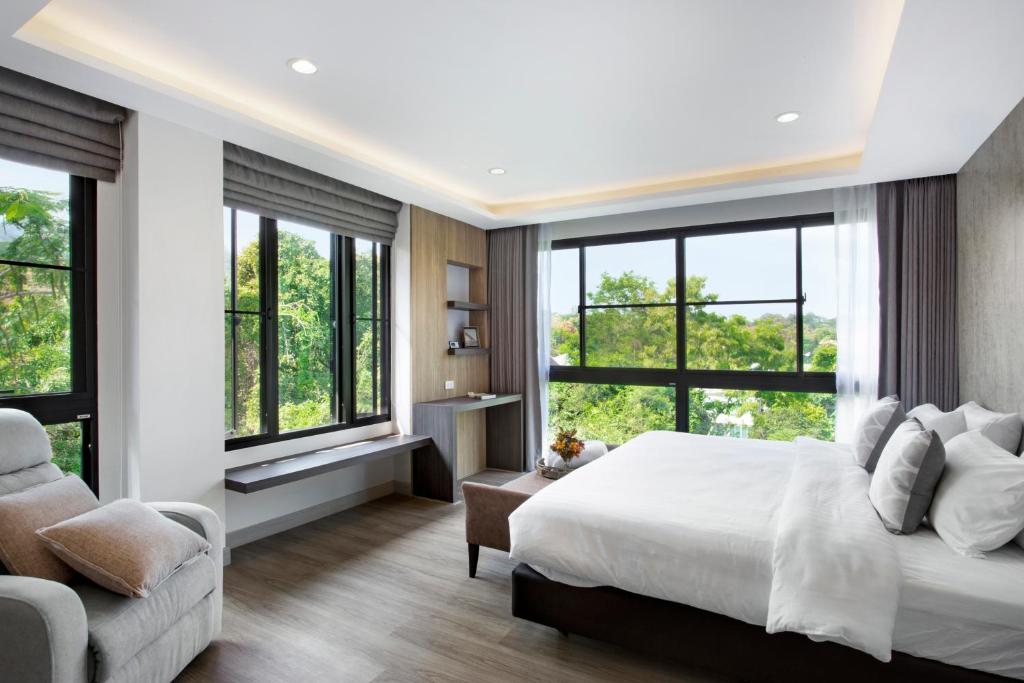 清迈Reiz - Private Residence的一间卧室配有一张床、一张沙发和窗户。