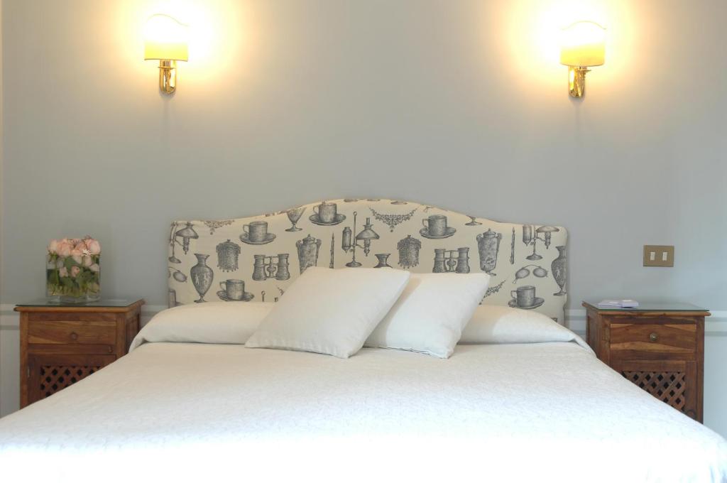 罗马兰斯洛特酒店的一间卧室配有一张白色床和两盏灯。