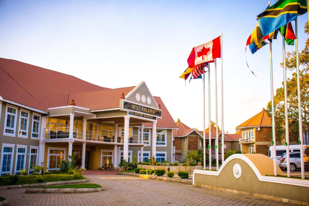阿鲁沙Masailand Safari Lodge的大楼前有旗帜的酒店